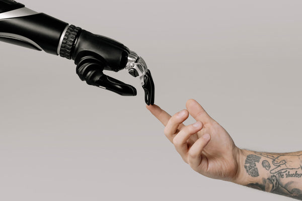 Foto einer Handprothese, die eine menschliche Hand berührt